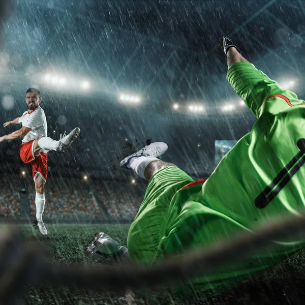 Fotbollsspelare utför en åtgärd-spela på en professionell stadion. Visa genom fotboll målet — Stockfoto