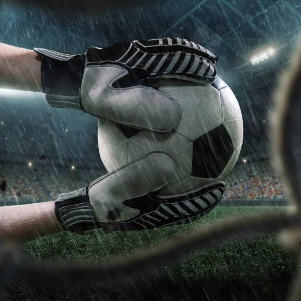 Soccer goalkeeper catches a ball. View through the football goal