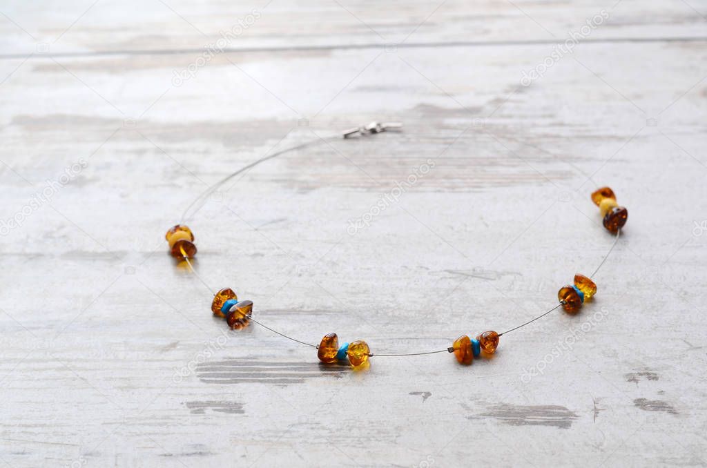 Bright orange amber necklace of raw beads Necklace of amber beads Amber beads string on an old gray wooden background