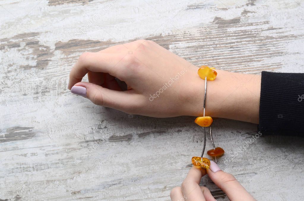 Bright orange amber necklace of raw beads Necklace of amber beads Amber beads string on an old gray wooden background