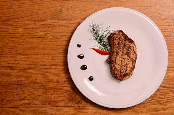 Groot stuk van zeldzame prime rib met gesneden groenten en een gebakken aardappel — Stockfoto