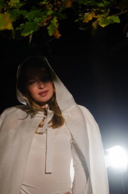Beyaz pelerinli gizemli genç kız, Şenlik ateşinin yanındaki ormanda cadı ayini, fantezi