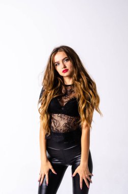 deri kıyafet giyen siyah saçlı kız tam uzunlukta portre. bir silah tutarken oturmuş poz, beyaz bir stüdyo arka plan üzerinde izole.