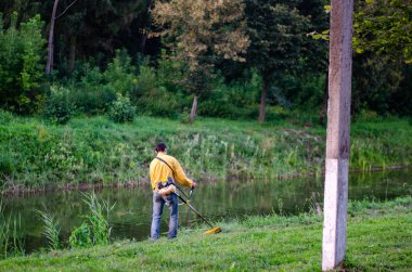 Park River yakınlarında metal dedektörüyle yürüyen bir adam. 
