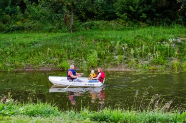Göldeki beyaz kayıkta bir aile