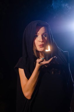 Siyah pelerin giyen gizemli genç kız, Şenlik ateşinin olduğu gece ormanda cadı ayini.