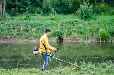 Park River yakınlarında metal dedektörüyle yürüyen bir adam. 