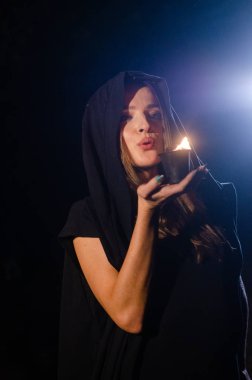 Siyah pelerin giyen gizemli genç kız, Şenlik ateşinin olduğu gece ormanda cadı ayini.