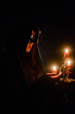 Siyah pelerin giyen gizemli genç kız, Şenlik ateşinin olduğu gece ormanda cadı ayini.
