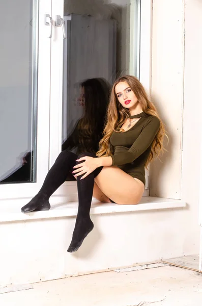 Sexig ung kvinna i svart sensuella underkläder. Flicka poserar på tegelväggen i studio. — Stockfoto
