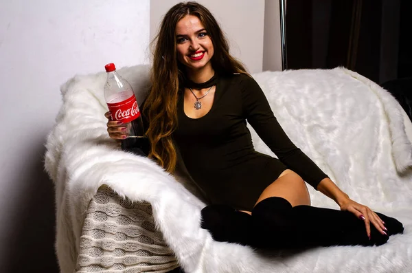 Γυναίκα που κρατάει ένα μπουκάλι κόκα έχει ένα χαρούμενο χαμόγελο. Η Coca Cola είναι αμερικανική εταιρεία ποτών ιδρύθηκε το 1886 από τον φαρμακοποιό. Ουκρανία, Λούτσκ 14-09-2018. — Φωτογραφία Αρχείου