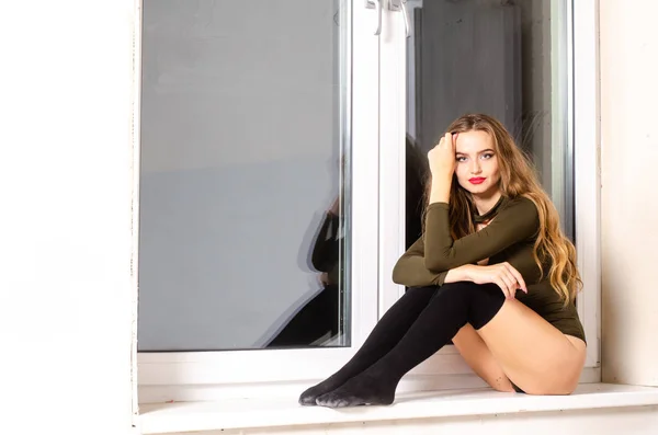 Sexy young woman in black sensual lingerie. Girl posing on brick wall in studio. — Stock Photo, Image