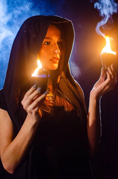 黒いマントを着た謎の少女 たき火で夜森の中の魔女の安息日 — ストック写真