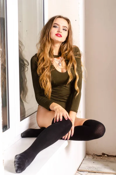 Sexy jonge vrouw in zwarte sensuele lingerie. Meisje die zich voordeed op bakstenen muur in studio. — Stockfoto