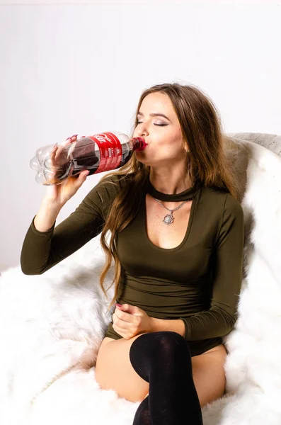 Γυναίκα που κρατάει ένα μπουκάλι κόκα έχει ένα χαρούμενο χαμόγελο. Η Coca Cola είναι αμερικανική εταιρεία ποτών ιδρύθηκε το 1886 από τον φαρμακοποιό. Ουκρανία, Λούτσκ 14-09-2018. — Φωτογραφία Αρχείου