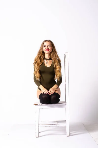 Jovem mulher sexy sentada na cadeira . — Fotografia de Stock