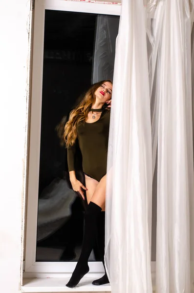 Sexig ung kvinna i svart sensuella underkläder. Flicka poserar på tegelväggen i studio. — Stockfoto