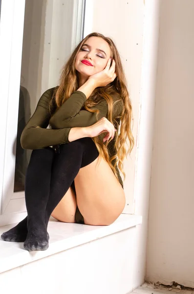 Sexy young woman in black sensual lingerie. Girl posing on brick wall in studio. — Stock Photo, Image