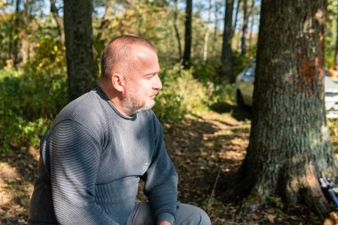 the man is in the autumn woods in the forest on the background of the trees.