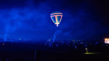 Sıcak hava balonu gökyüzünün altında Samanyolu ve geceleri parlayan yıldızla muhteşem bir Kapadokya üzerinde uçuyor. 