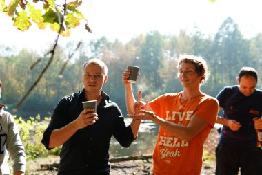 Ormanda gölün kenarında çay içen bir adam.