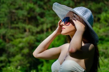 Şapkalı kız güneşli göl sahillerinde vakit geçiriyor. 