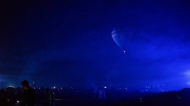 Sıcak hava balonu gökyüzünün altında samanyolu ve parlayan yıldızla (buğday taneleriyle) muhteşem bir kapadokya üzerinde uçuyor.)