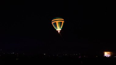 Sıcak hava balonu gökyüzü altında Samanyolu ve geceleri parlayan yıldızla muhteşem bir kapadokya uçuyor.  