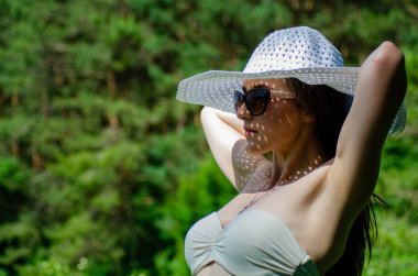 Şapkalı kız güneşli göl sahillerinde vakit geçiriyor. 