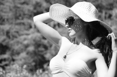 Şapkalı kız güneşli göl sahillerinde vakit geçiriyor. 