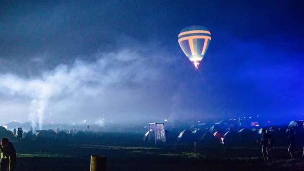 Balão de ar quente voando sobre a espetacular Capadócia sob o céu com forma leitosa e brilhante estrela à noite (com grãos ) — Fotografia de Stock