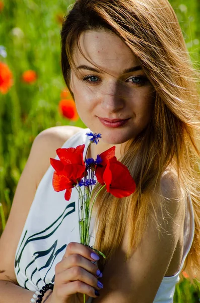 Jolie femme dans le domaine des coquelicots — Photo