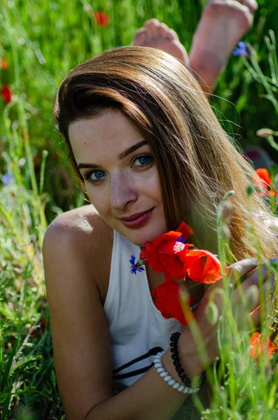 Jolie femme dans le domaine des coquelicots — Photo