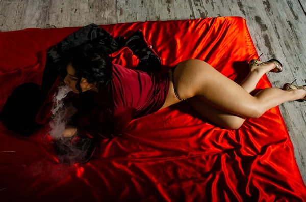 Sexy junge Frau in einer schwarzen Dessous, die im Schlafzimmer dampft. schöne brünette Frau rauchen — Stockfoto