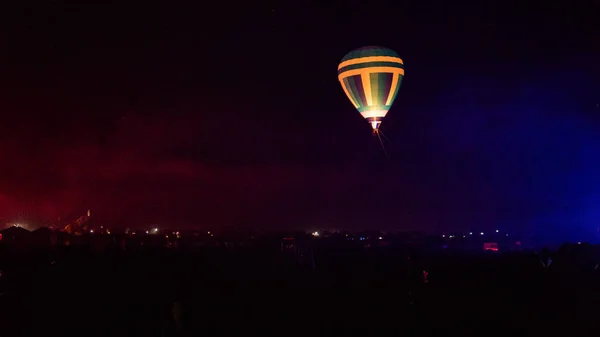 Horkovzdušný balón letící nad velkolepou Cappadocií pod oblohou s mléčnou dráhou a zářící hvězdou v noci (s obilím) — Stock fotografie