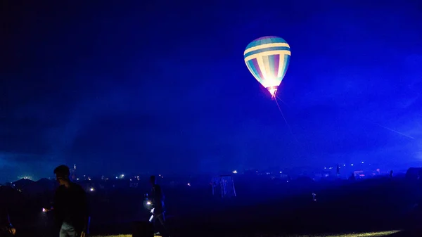 Varm luft ballong flyger över spektakulära Kappadokien under himlen med mjölkaktig sätt och shininng stjärna på natten (med spannmål) — Stockfoto