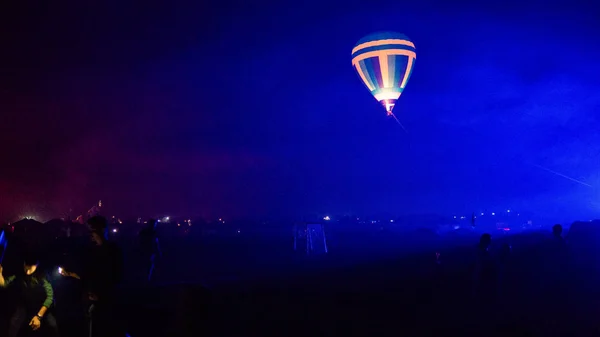 Balon na gorące powietrze przelatujący nad spektakularną Kapadocją pod niebem z Drogą Mleczną i świecącą gwiazdą w nocy (z ziarnem) — Zdjęcie stockowe