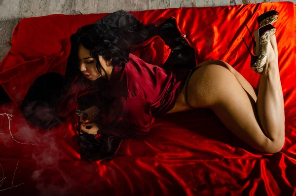 Sexy junge Frau in einer schwarzen Dessous, die im Schlafzimmer dampft. schöne brünette Frau rauchen — Stockfoto