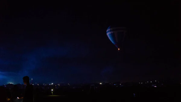 Balon na gorące powietrze przelatujący nad spektakularną Kapadocją pod niebem z Drogą Mleczną i świecącą gwiazdą w nocy (z ziarnem) — Zdjęcie stockowe