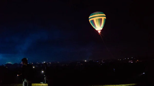 Varm luft ballong flyger över spektakulära Kappadokien under himlen med mjölkaktig sätt och shininng stjärna på natten (med spannmål) — Stockfoto