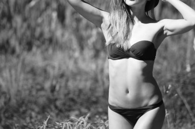 Kız şapka ve gözlük sahilde poz bir mayo