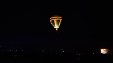 Sıcak hava balonu gökyüzü altında Samanyolu ve geceleri parlayan yıldızla muhteşem bir kapadokya uçuyor.  