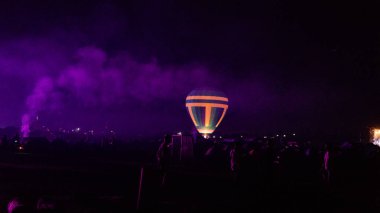 Sıcak hava balonu gökyüzünün altında Samanyolu ve geceleri parlayan yıldızla muhteşem bir Kapadokya üzerinde uçuyor.  
