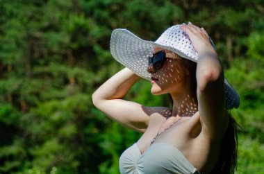 Şapkalı kız güneşli göl sahillerinde vakit geçiriyor. 