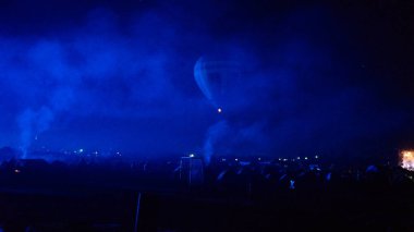 Sıcak hava balonu gökyüzünün altında Samanyolu ve geceleri parlayan yıldızla muhteşem bir Kapadokya üzerinde uçuyor. 