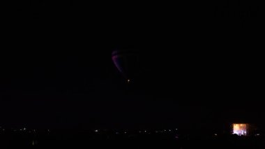 Sıcak hava balonu gökyüzü altında Samanyolu ve geceleri parlayan yıldızla muhteşem bir kapadokya uçuyor.  