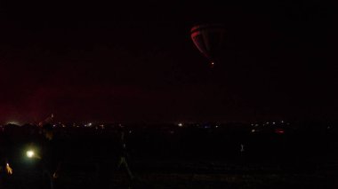 Sıcak hava balonu gökyüzünün altında samanyolu ve parlayan yıldızla (buğday taneleriyle) muhteşem bir kapadokya üzerinde uçuyor.)