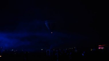 Sıcak hava balonu gökyüzü altında Samanyolu ve geceleri parlayan yıldızla muhteşem bir kapadokya uçuyor.  