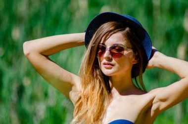 Kız şapka ve gözlük sahilde poz bir mayo