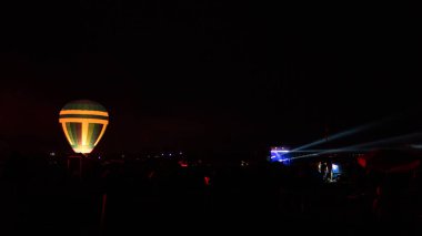 Sıcak hava balonu gökyüzü altında Samanyolu ve geceleri parlayan yıldızla muhteşem bir kapadokya uçuyor.  